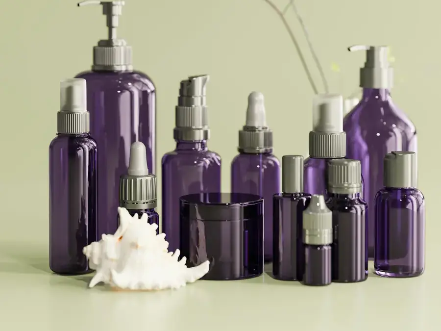 Frascos de vidro roxo de vários tamanhos sobre fundo verde-claro