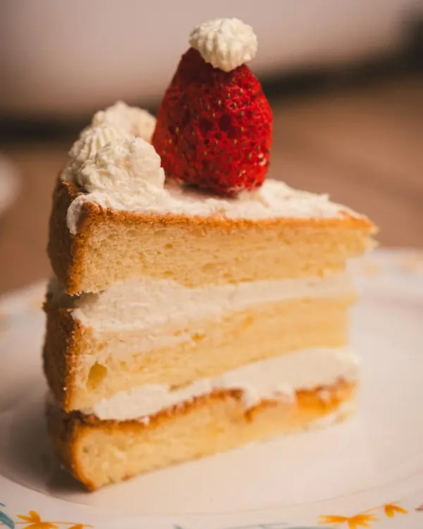 Fatia de bolo de camadas com creme e um morango no topo