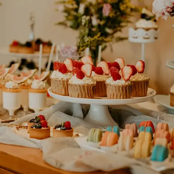 Mesa de festa com cupcakes de morango e docinhos