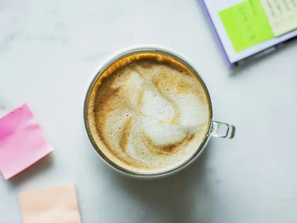 Xícara de café e blocos de notas sobre a mesa