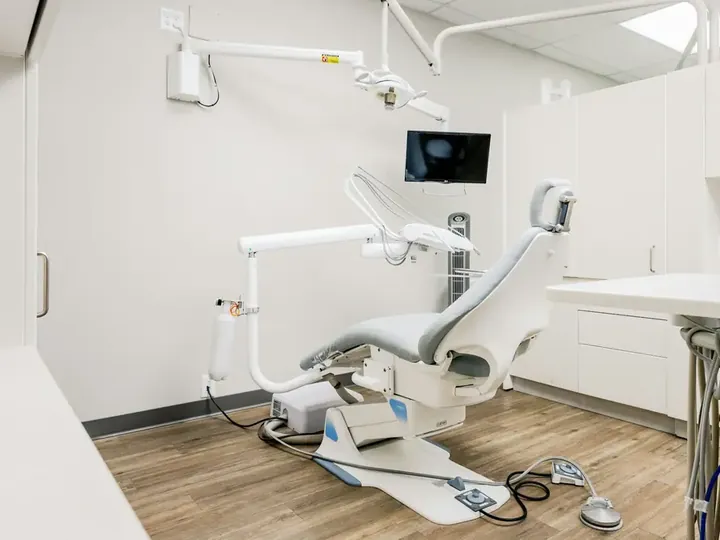 Consultório com cadeira odontológica e monitor