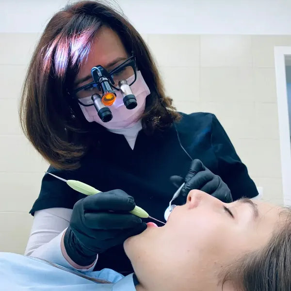 Dentista com lupa de aumento examina a paciente