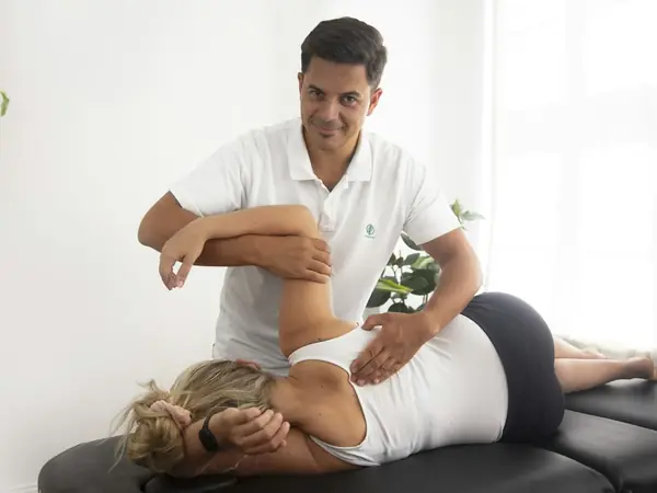 Fisioterapeuta atende uma paciente deitada na maca